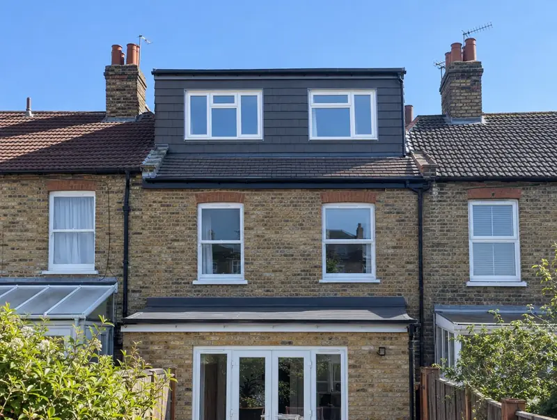 Full-width rear dormer loft conversion clad in dark tiles on a brick terraced house